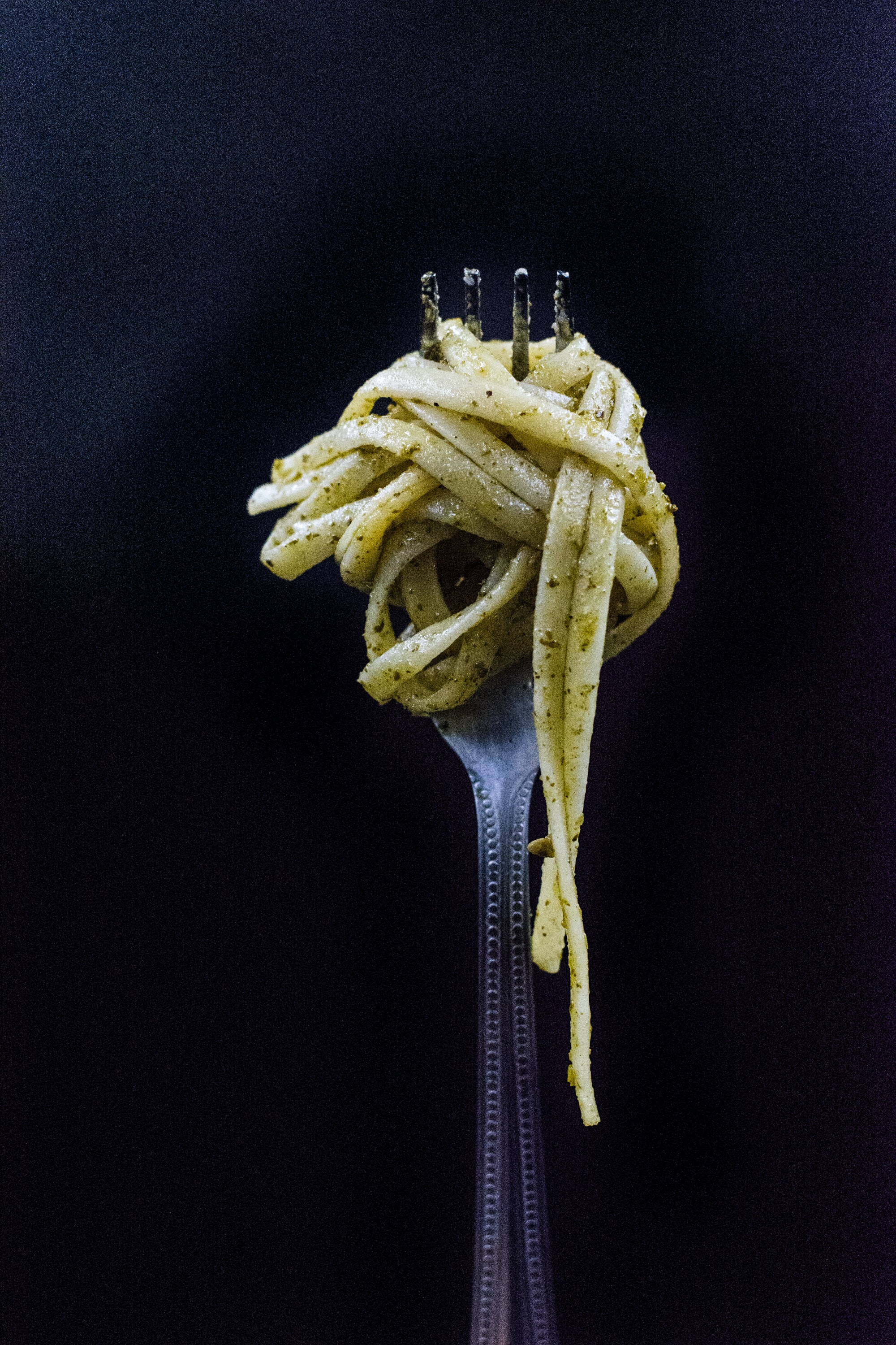 Pesto pasta wrapped around a fork